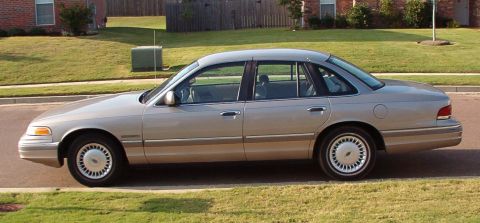 1994 Ford Crown Victoria - Side profile of a silver 1994 Ford Crown Victoria sedan parked on a suburban street.