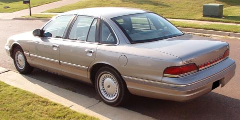 1994 Ford Crown Victoria - This sedan is parked on the side of the road with grass and a curb in the foreground.