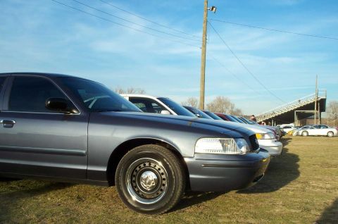1998 Ford Crown Victoria - A row of sedans, including a 1998 Ford Crown Victoria, are parked at Edgewater Raceway.