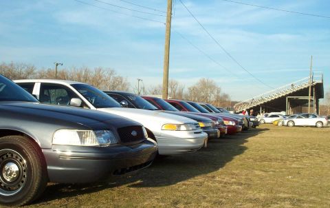 1998 Ford Crown Victoria - Several Ford Crown Victoria police cars are parked in a row on a sunny day at what appears to be a racetrack.