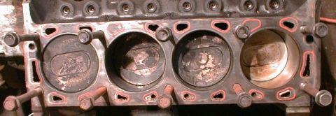 1990 Ford Bronco - Close-up of an engine block with pistons visible inside the cylinders.
