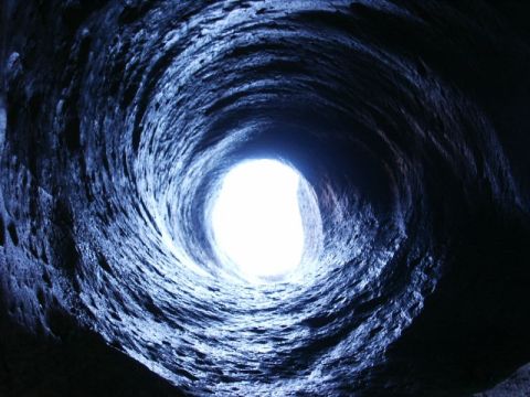 1996 Ford Bronco - Looking through a dark, textured tunnel towards a bright opening.