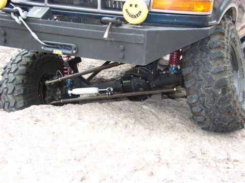 1994 Ford Bronco - Close-up of the front axle and suspension system on a 1994 Ford Bronco, modified for off-road use.