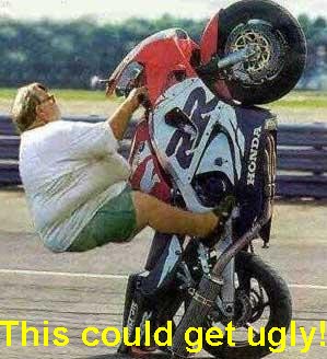 1995 Ford Bronco - A person performs a stunt on a motorcycle, lifting the front wheel off the ground.