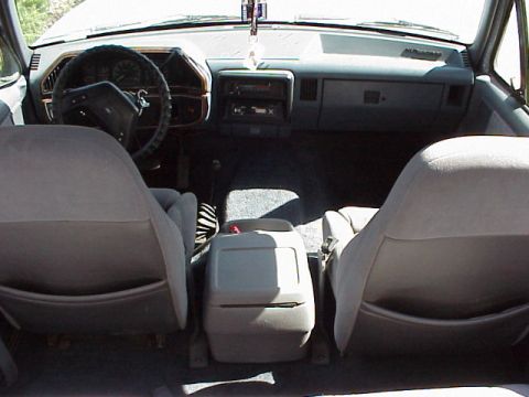 1989 Ford Bronco - The interior of a 1987 Ford Bronco is captured from the rear, revealing the dashboard and seating arrangement.