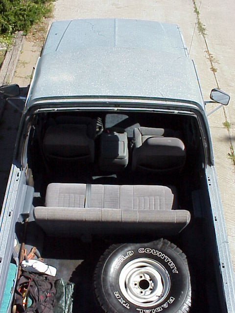 1989 Ford Bronco - Top-down view of a light-colored SUV's interior, showing seats and cargo space.