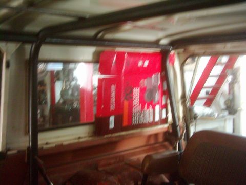 1978 Ford Bronco - Red boxes are stacked inside a vehicle's interior, with a roll cage visible overhead.