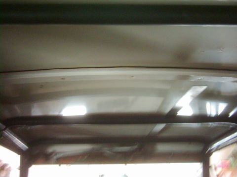 1978 Ford Bronco - The interior roof structure of a vehicle is visible, showing metal beams and lighting elements.