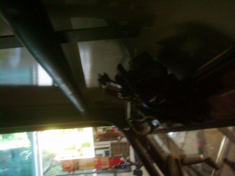 1978 Ford Bronco - A dark interior shot shows a metal roll cage structure installed above the occupants.
