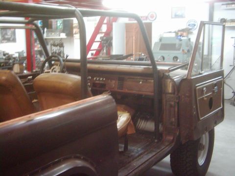 1978 Ford Bronco - The interior of a classic Ford Bronco is shown, a roll cage and tan upholstery, suggesting it's undergoing restoration or modification.