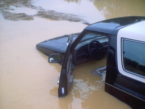 1995 Ford Bronco - This 1995 Ford Bronco is stuck in deep, muddy water with the driver's door ajar.