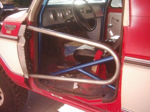 1978 Ford Bronco - Interior view of a 1978 Ford Bronco, modified with a roll cage and custom door bars.