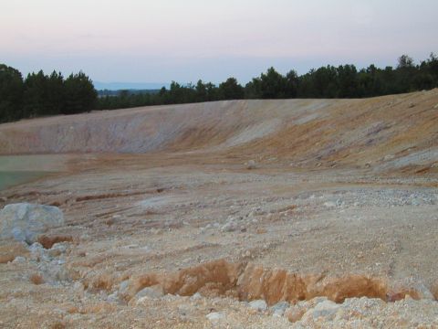 1989 Ford Bronco - A wide view of a quarry with layered dirt and rock formations under a dusky sky.