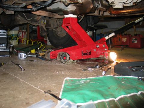 1995 Ford Bronco - Vehicle maintenance in progress, showing the underside with tools and a jack.
