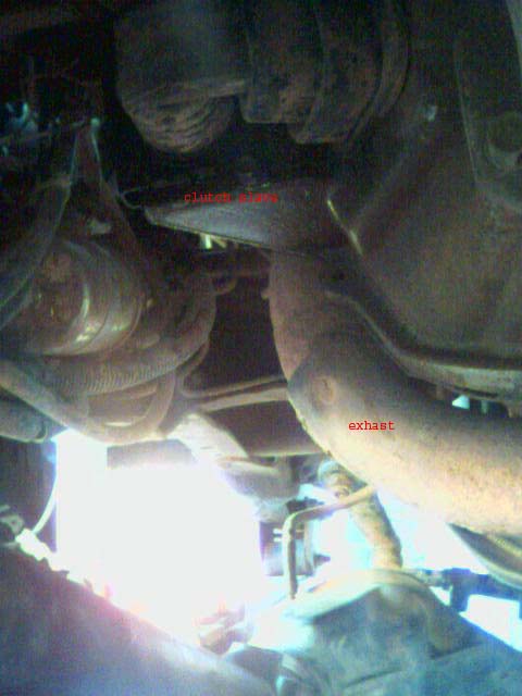 1987 Ford Bronco - Close-up view of the undercarriage, focusing on the exhaust system and clutch area.