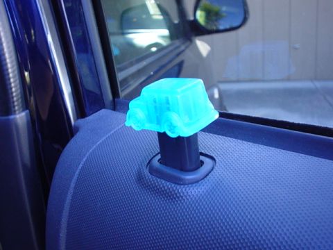 1993 Ford Taurus - A blue, translucent car-shaped air freshener is attached to the interior door latch mechanism.