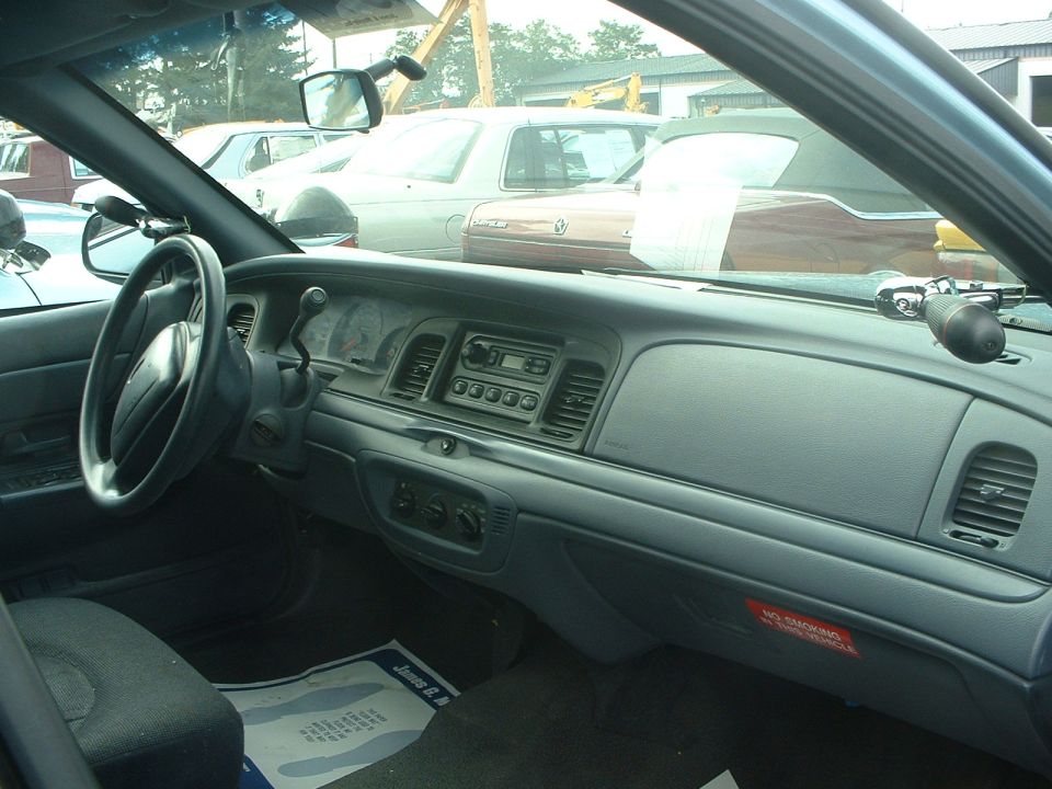 Gray car interior dashboard and steering wheel viewed from passenger seat