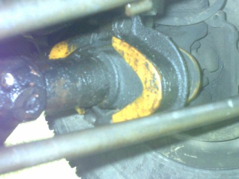1995 Ford Bronco - A close-up view of a vehicle's driveshaft U-joint, showing grease and yellow paint markings.