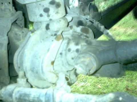 1995 Ford Bronco - A close-up view of a vehicle's front axle assembly, showing grease and dirt accumulation.