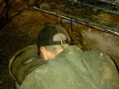1995 Ford Bronco - Mechanic working on a vehicle component, likely a wheel or brake assembly.