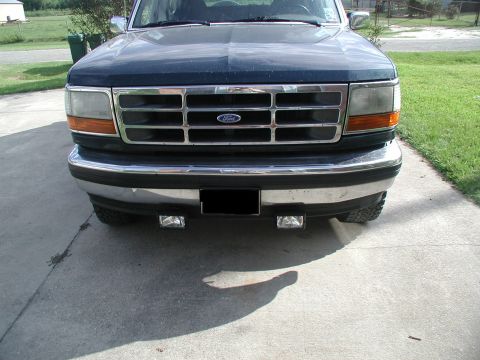 1993 Ford Bronco - Front view of a dark blue 1993 Ford Bronco, its distinctive grille and chrome bumper.