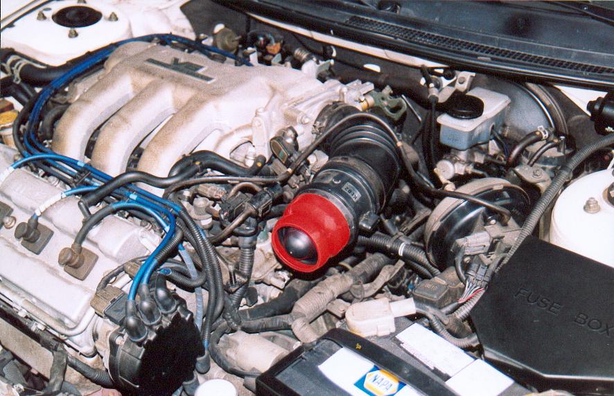 Engine bay with V6, blue plug wires, and red cone air intake filter