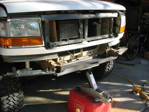 1995 Ford Bronco - Front view of a white 1995 Ford Bronco with a custom winch mount bumper being installed.