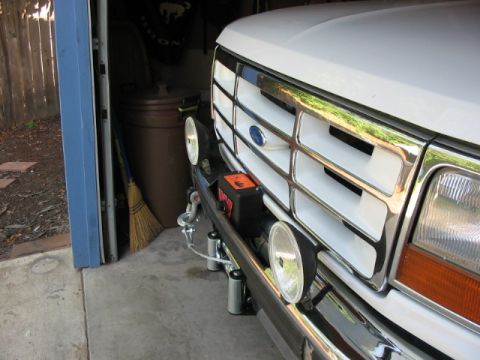 1995 Ford Bronco - Close-up of a white Ford truck's front end, showing the grille and a winch assembly.
