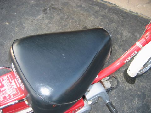 1985 Ford LTD Crown Victoria - Close-up of a moped seat and red frame with 'YAMAHA' branding.