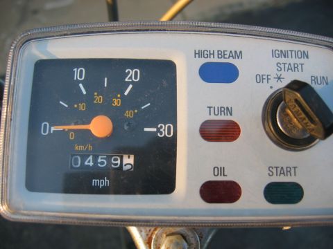 1985 Ford LTD Crown Victoria - Close-up of a motorcycle's instrument cluster, a speedometer and various indicator lights for high beam, turn signals, oil, and ignition.