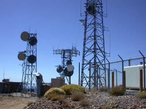 1996 Ford Bronco - A landscape view of multiple telecommunications towers situated on a rocky terrain under a bright blue sky.