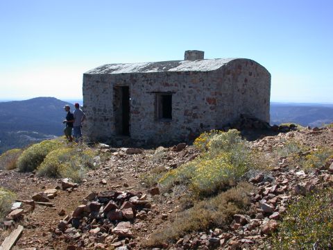 1996 Ford Bronco - A stone structure sits atop a hill overlooking a valley, with two individuals observing the landscape.