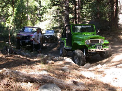 1996 Ford Bronco - Several off-road vehicles navigate a rocky, wooded trail during an outing.
