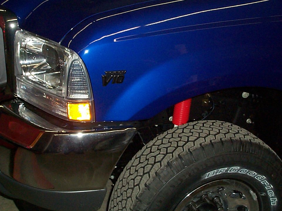 Blue Ford Super Duty front fender with Triton V10 badge and BFGoodrich tire