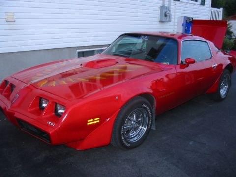 1985 Ford Bronco - This red Pontiac Firebird Trans Am features flame decals and a prominent hood scoop.