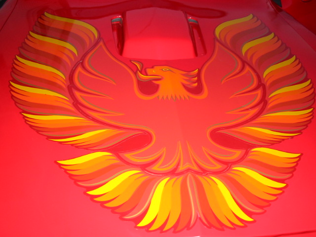 Red car hood with a large, colorful phoenix decal and two hood scoops