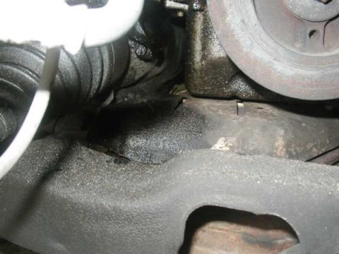 1993 Ford Taurus - Close-up view of engine components showing signs of oil leakage.