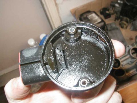 1993 Ford Taurus - The interior of a distributor cap shows significant oil buildup and grime.