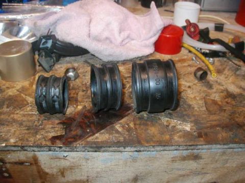 1993 Ford Taurus - Three rubber bushings are laid out on a workbench, with one clearly showing the part number F78B-00-00.