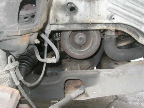 1993 Ford Taurus - Underside view of engine bay components, showing a pulley, hoses, and part of the suspension system.