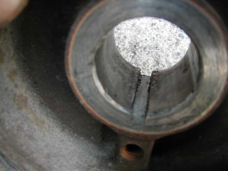 Close-up of a damaged metal pipe interior with debris