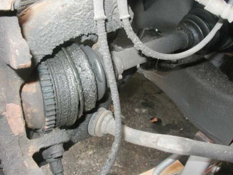 1993 Ford Taurus - Detail of a CV axle joint, likely needing replacement due to a damaged grease boot.