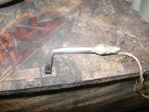 1993 Ford Taurus - An Allen wrench with twine attached to one end is shown on a wooden surface.