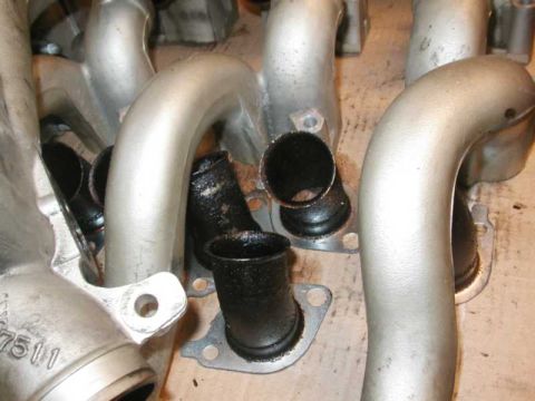 1993 Ford Taurus - Several intake manifold pipes are shown, with some exhibiting significant carbon deposits within their openings.