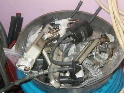 1993 Ford Taurus - A collection of various automotive parts, such as spark plugs and electrical components, are stored together.