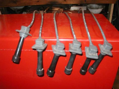 1993 Ford Taurus - Set of six spark plug wires on a red surface, likely for an engine.