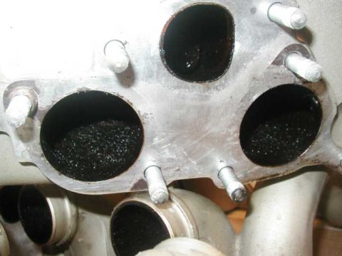 1993 Ford Taurus - The exhaust manifold ports are heavily clogged with carbon deposits.