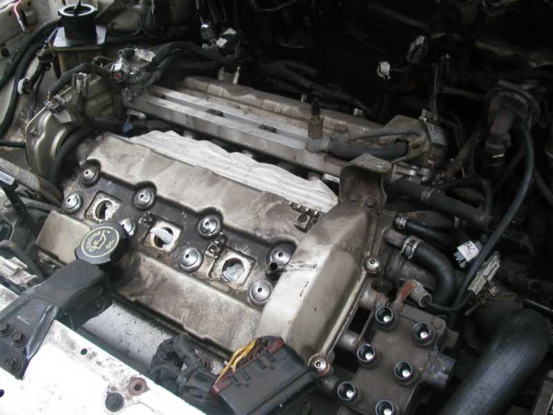 engine bay with valve covers removed, showing spark plug wells and intake manifold