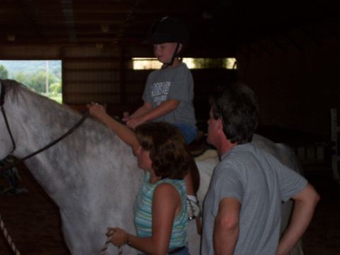 1994 Ford Bronco - A child rides a horse while adults assist in a barn setting.