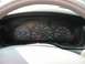 2002 Ford Taurus - Very small, low-resolution photo of a car's instrument cluster behind the steering wheel, showing the round speedometer and tachometer dial…